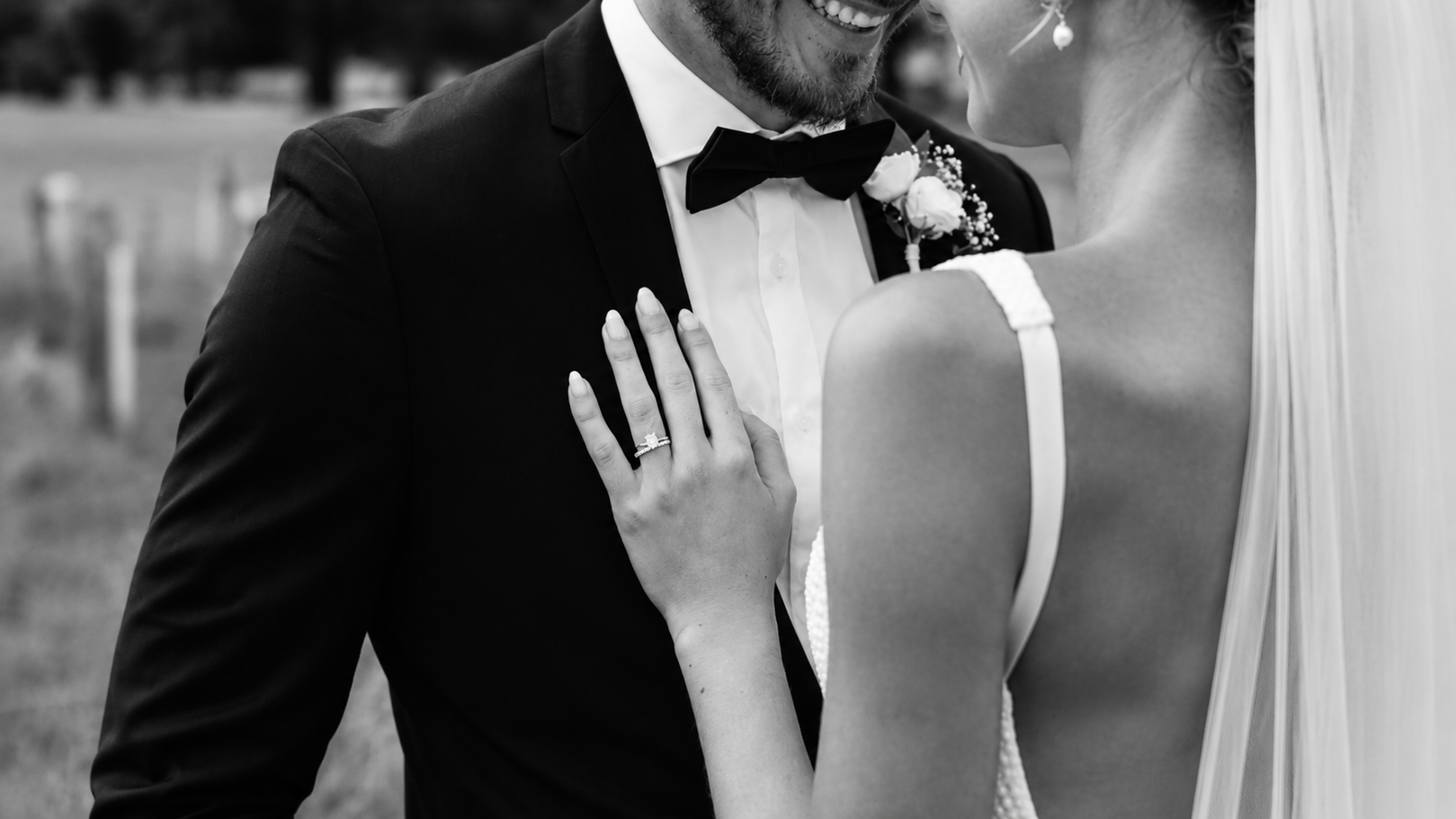Black and white photo of a couple in formal attire with a blurred background
