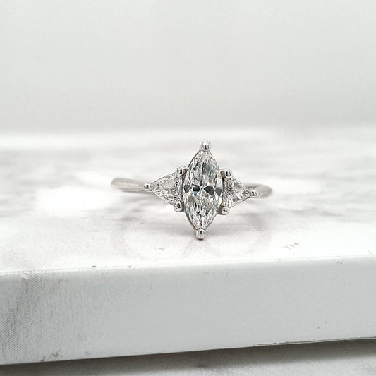 18ct White Gold 0.71ct Marquise Cut Diamond with 0.21ct Accent Trilliant Cut Diamond Claw Set Three Stone Ring