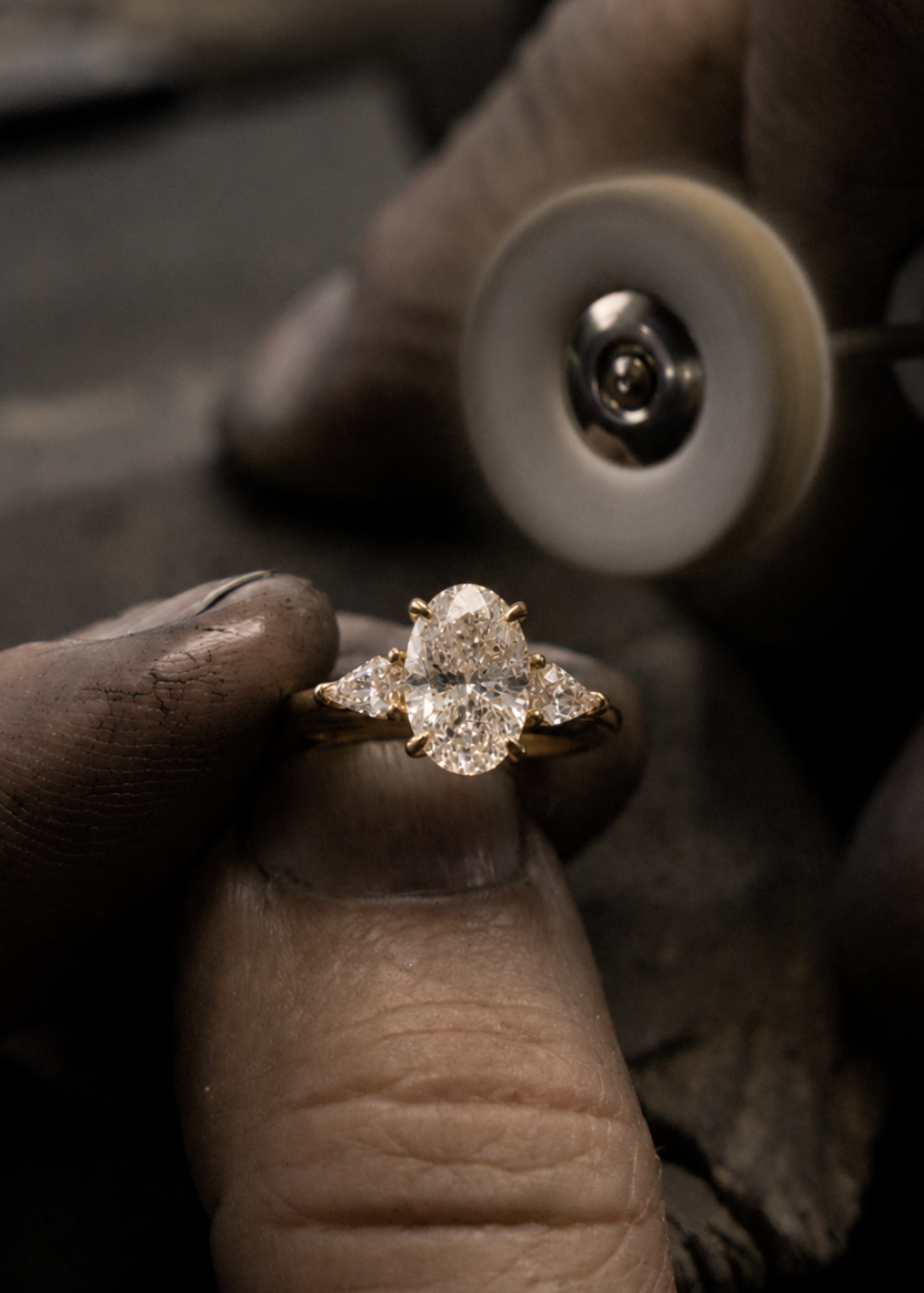 Diamond ring held between fingers with a magnifying glass in the background